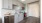 Spacious and well lit kitchen with wood floors and stainless steel appliances. 